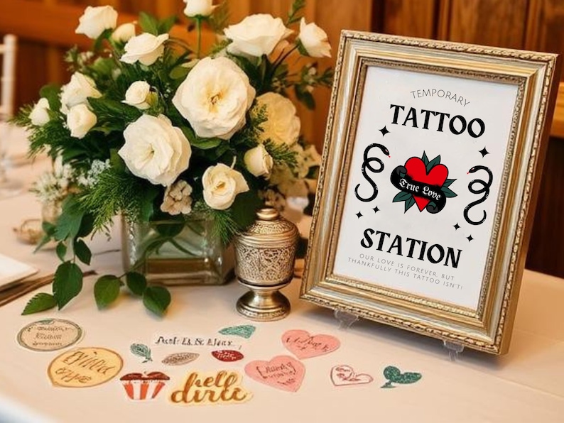 K&ouml;nnte beinhalten: Ein Schild f&uuml;r eine tempor&auml;re Tattoo-Station auf einer Hochzeit. Das Schild ist golden mit wei&szlig;em Hintergrund und tr&auml;gt die Aufschrift "Temporary Tattoo Station" mit einem Herz und den Worten "True Love".