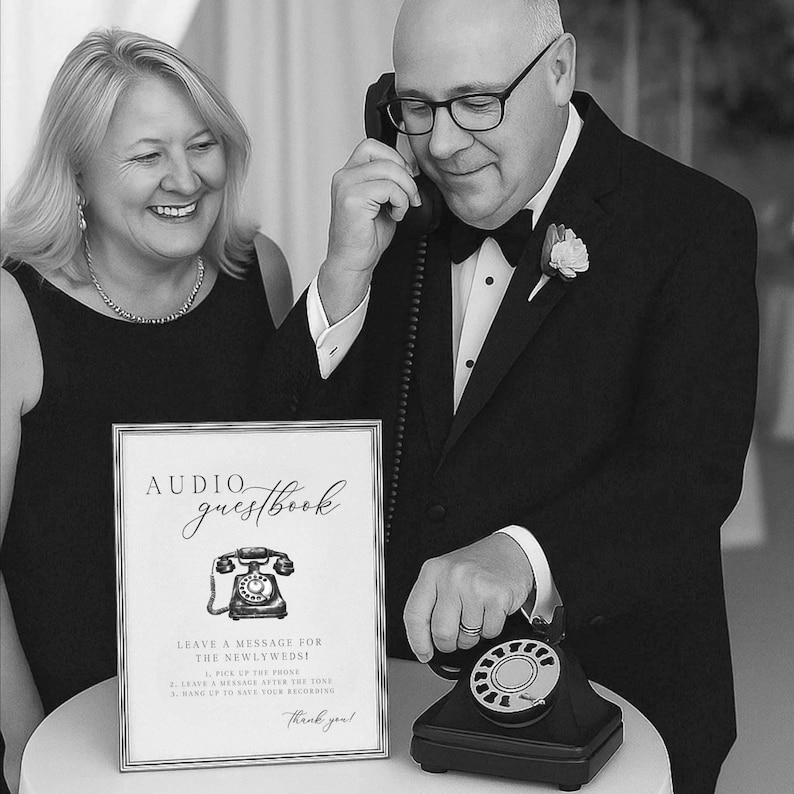 K&ouml;nnte beinhalten: Schwarz-Wei&szlig;-Bild eines Audio-G&auml;stebuchs f&uuml;r Hochzeiten. Ein gerahmtes Schild mit den Worten "Audio Guestbook" und Anweisungen steht vor einem schwarzen Vintage-Drehtelefon. Ein Mann im Smoking h&auml;lt das Telefon an sein Ohr.