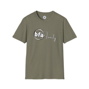 May include: Olive green t-shirt with short sleeves. The front features the text "bfa Family" in a white and black circular design. The shirt has a crew neck and a small tag on the upper back.