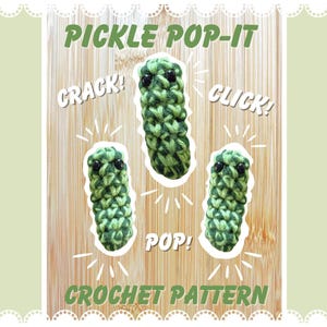 May include: A wooden background features three green crochet pickle toys with black eyes. The text "PICKLE POP-IT" and "CROCHET PATTERN" are at the top and bottom. The words "CRACK!", "CLICK!", and "POP!" are also included.