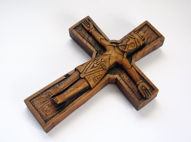 Pu&ograve; includere: Un crocifisso in legno con una scultura dettagliata di Ges&ugrave; Cristo. La croce &egrave; marrone e ha una superficie testurizzata.