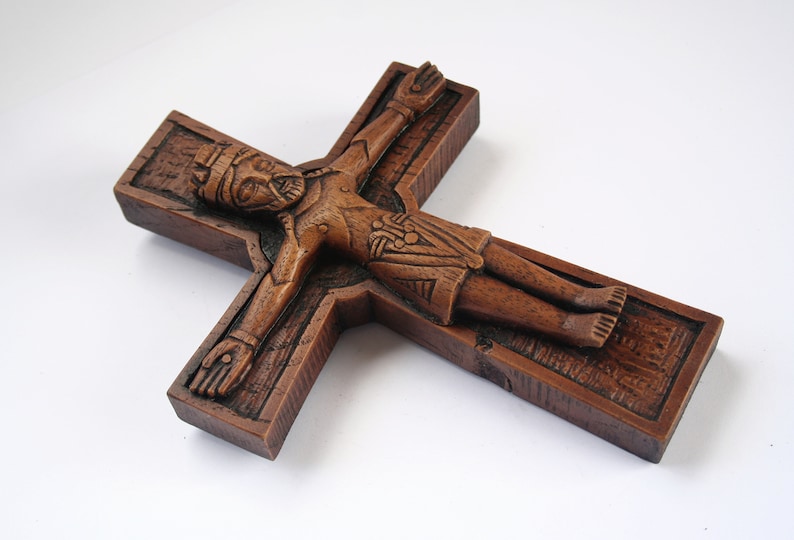 Pu&ograve; includere: Un crocifisso in legno con una scultura dettagliata di Ges&ugrave; Cristo. La croce &egrave; di colore marrone scuro e ha una superficie testurizzata.