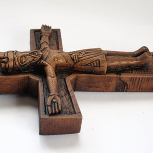 Pu&ograve; includere: Un crocifisso in legno con una figura scolpita di Ges&ugrave; Cristo. La croce &egrave; di colore marrone scuro e ha un aspetto rustico.