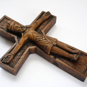 Pu&ograve; includere: Un crocifisso in legno con una figura scolpita di Ges&ugrave; Cristo. La croce &egrave; di colore marrone scuro e la figura &egrave; dettagliata con una corona di spine e un perizoma.