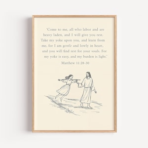 May include: Framed print featuring a Bible verse from Matthew 11:28-30, with a black and white illustration of Jesus and a woman. The artwork is set against a cream-colored background, encased in a wooden frame.