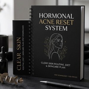 May include: A black spiral-bound book and a smaller black booklet. The larger book reads "HORMONAL ACNE RESET SYSTEM" with a line drawing of a woman's face. The smaller booklet reads "CLEAR SKIN". Both books have text about skincare routines and diet.