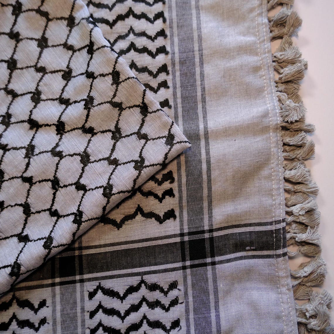 كوفية فلسطينية رمادية زرقاء بنمط هندسي تقليدي ونسيج خفيف ملتف لإظهار التفاصيل (3)