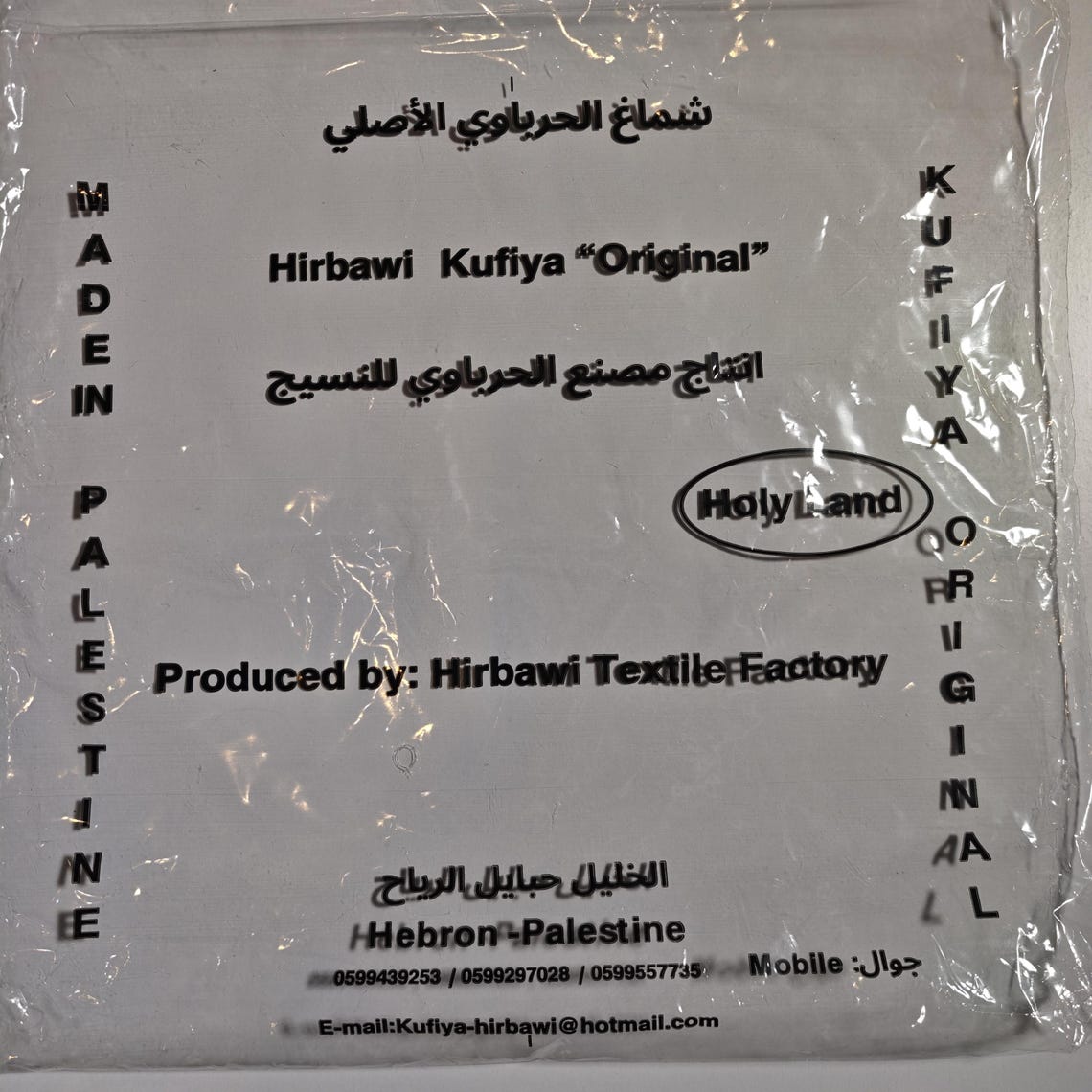كوفية فلسطينية سوداء وبيضاء مطوية بنقوش هندسية وخطوط منسوجة (5)