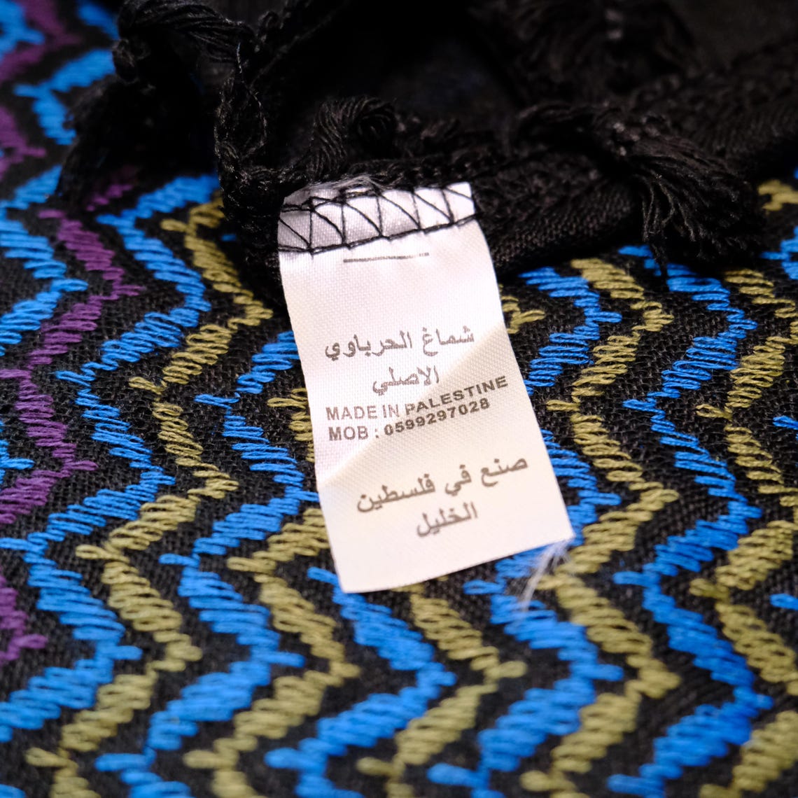 كوفية سوداء بنقشة شيفرون ملوّنة بخطوط صفراء وخضراء وبنفسجية وزرقاء (7)