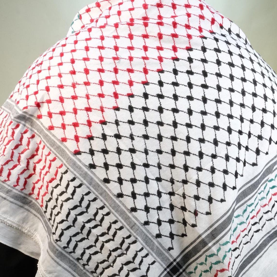 كوفية بيضاء بنقوش هندسية سوداء وحمراء وخضراء مستوحاة من علم فلسطين (2)