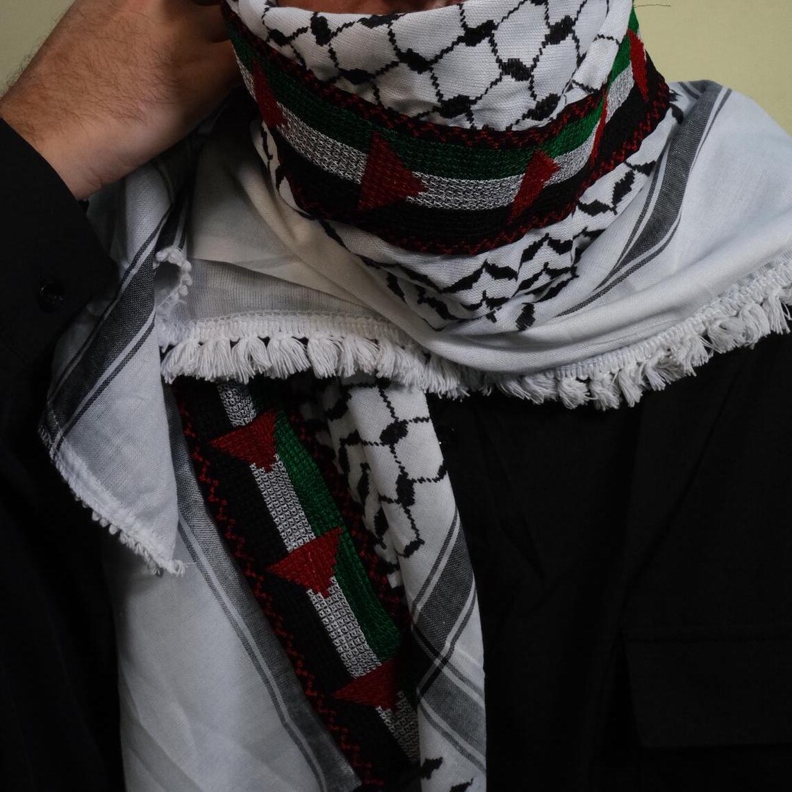 كوفية فلسطينية بيضاء وسوداء مطوية بنقشة هندسية تقليدية وتفاصيل شرّابات (4)