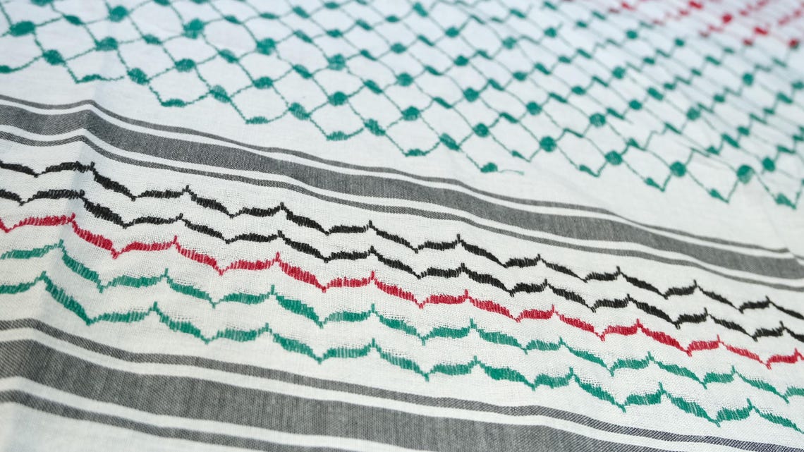 كوفية بيضاء بنقوش هندسية سوداء وحمراء وخضراء مستوحاة من علم فلسطين (4)