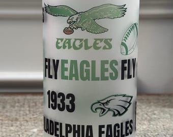 May include: A white frosted glass with a green and black Philadelphia Eagles logo and the text "Fly Eagles Fly" and "1933".