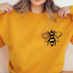 May include: A yellow sweatshirt with a black bee graphic on the front.
