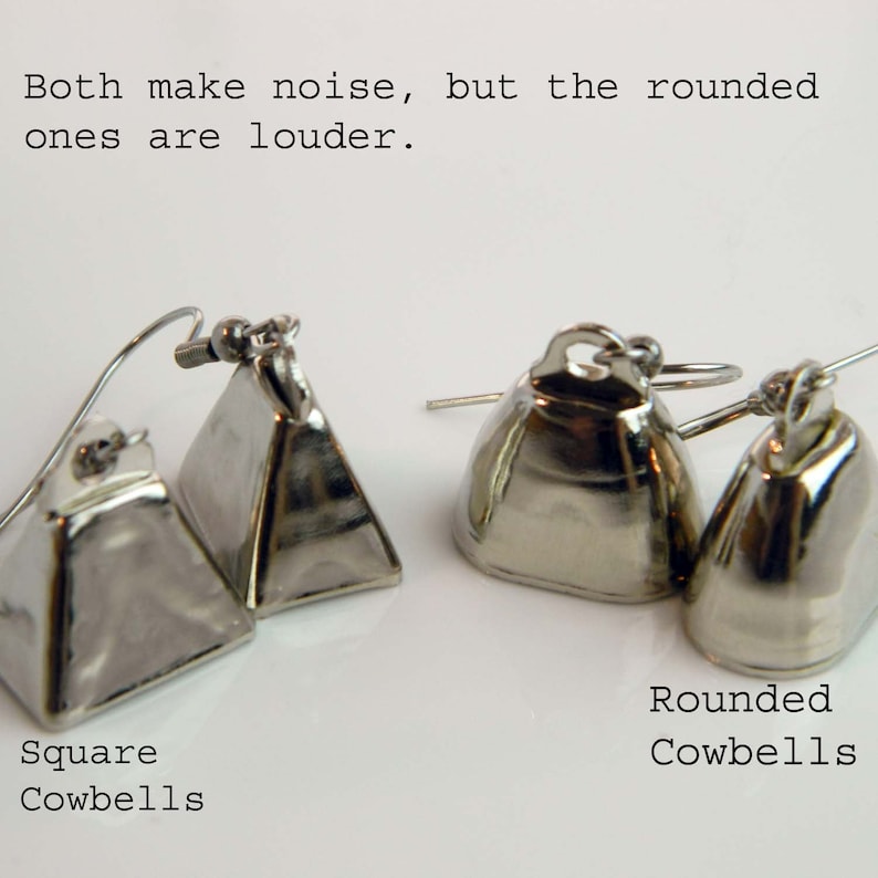 May include: Two pairs of silver-toned metal cowbell earrings with ear wires. The left pair features square-shaped bells, while the right pair features rounded bells. Text on the image reads: Both make noise, but the rounded ones are louder. Square Cowbells. Rounded Cowbells.