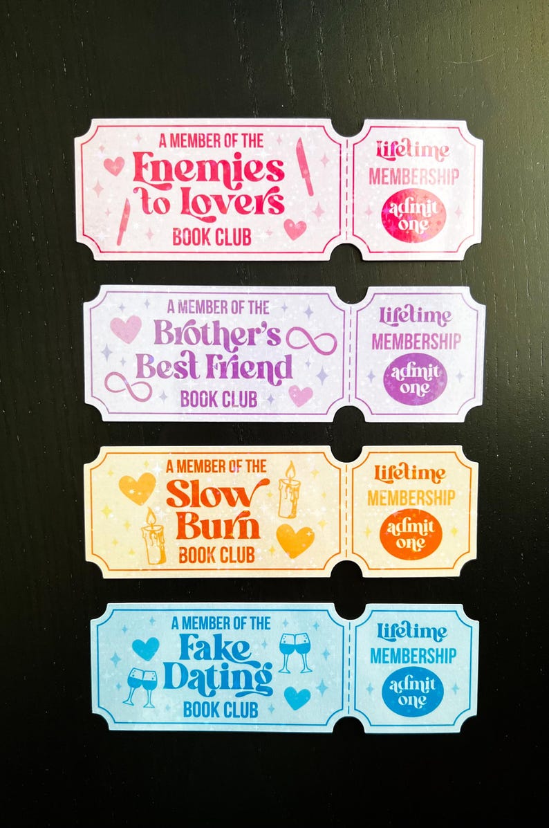 May include: Four colourful book club membership cards with text and illustrations. The cards read "Enemies to Lovers," "Brother's Best Friend," "Slow Burn," and "Fake Dating" book clubs. Each card has a matching "Lifetime Membership" card.