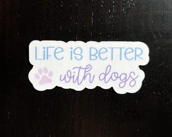 May include: White sticker with a paw print and the text "Life is better with dogs" in blue and purple lettering.