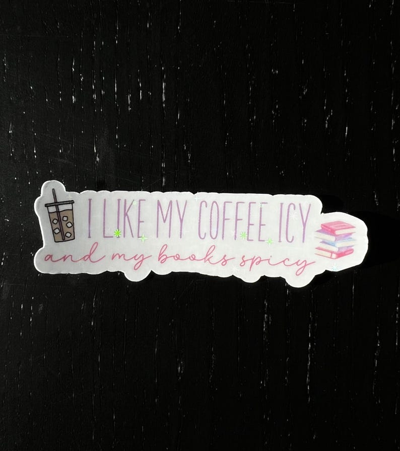 May include: A white sticker with pink and green text that reads "I like my coffee icy and my books spicy". A cartoon drawing of a cup of iced coffee and a stack of books are on either side of the text.