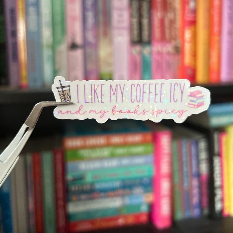 May include: A white sticker with a glittery finish features a cartoon illustration of a cup of iced coffee and the text "I like my coffee icy and my books spicy".