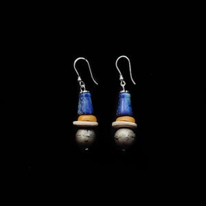 May include: A pair of dangle earrings with blue, orange, and silver beads. The earrings have a silver hook.