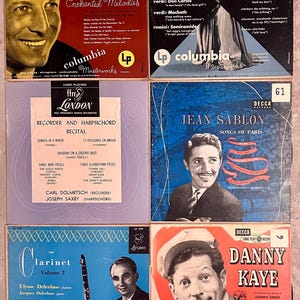 May include: A collection of six vintage vinyl records featuring various artists and genres. The records are in different colors and have a variety of designs. The records are all in good condition and would be a great addition to any music lover's collection.