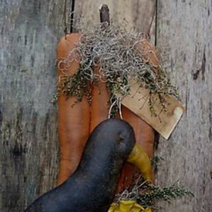 May include: A rustic fall decoration featuring two gourds with a black bird perched on top. The gourds are decorated with dried moss and a small tag that reads "Fall".