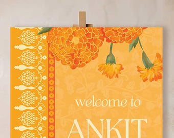 May include: A rectangular vertical sign with a bright orange background featuring illustrations of orange marigold flowers at the top. The left side has a white decorative border. The text reads "welcome to ANKIT and ALIA'S" in white.