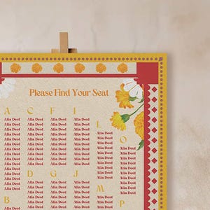 Puede incluir: Un plano de asientos con un borde rojo y amarillo y un diseño floral. El plano está titulado "Por favor, encuentre su asiento" y enumera nombres debajo de las letras del alfabeto.
