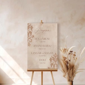 May include: A beige wedding program sign with a decorative floral design. The sign lists the events of the day, including tea and milni, Anand Karaj, Langar and Sagan, and Doli, with corresponding times.