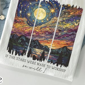 Pu&ograve; includere: T-shirt bianche e verde muschio con una grafica colorata di un cielo notturno, luna e montagne. Il testo "IF THE STARS WERE MADE TO WORSHIP, so will I" &egrave; stampato sulle magliette. Una t-shirt grafica religiosa/di fede.