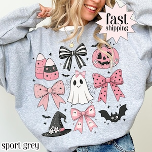 May include: Sport grey sweatshirt with a Halloween-themed design. The design includes candy corn, bows, a ghost, a pumpkin, a witch hat, and bats. The words "fast shipping" are in a starburst.