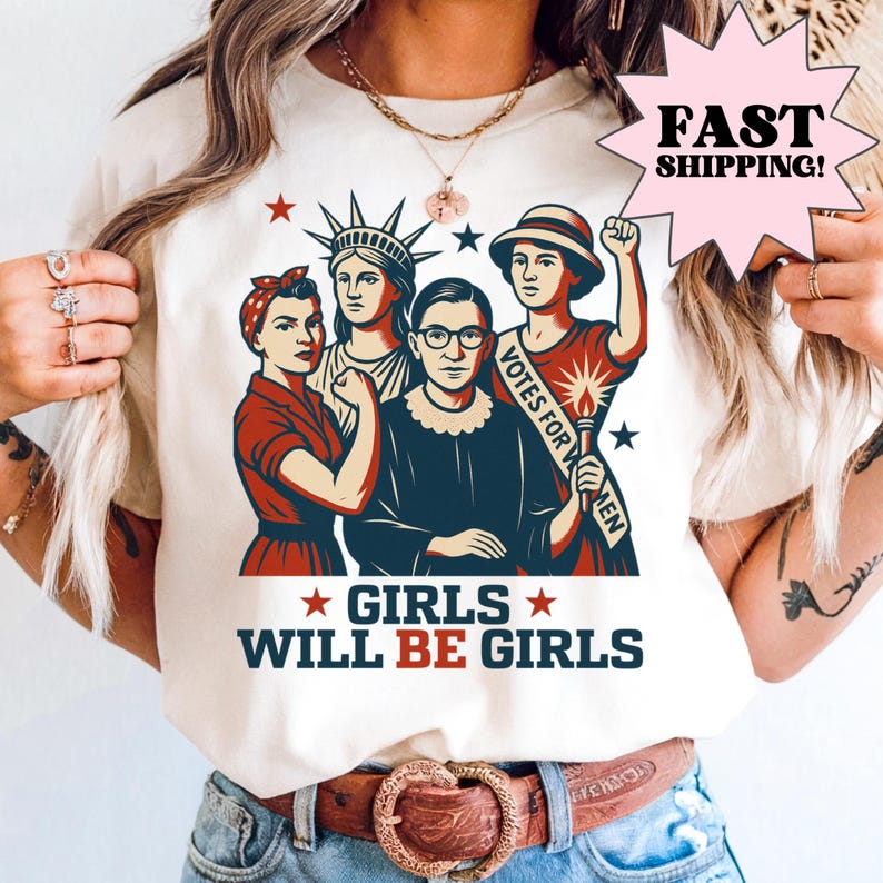 Cream graphic shirt featuring illustrated feminist icons inspired by historical women leaders with bold “Girls Will Be Girls” text. Feminist graphic tee designed as a women’s rights shirt, empowerment statement shirt, vintage-style illustration tee, and social justice apparel for everyday wear