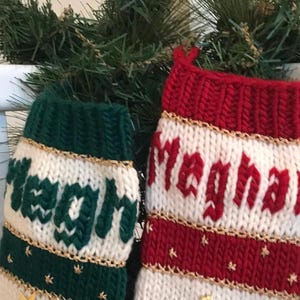 以下が含まれることがあります： 金色のトリムと「Meghan」と「Meghan」という名前が刺繍された、ニット製のクリスマスストッキングが2つです。