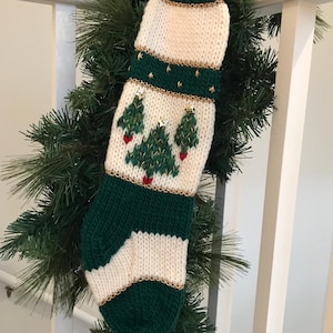 以下が含まれることがあります： 緑と白のニットのクリスマスストッキングで、金と赤のアクセントがついたクリスマスツリーが3本デザインされています。