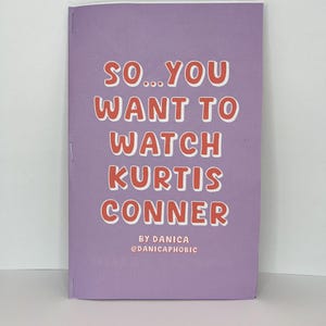 May include: A purple booklet with the text "SO...YOU WANT TO WATCH KURTIS CONNER" in red. The text "BY DANICA @DANICAPHOBIC" is printed in black at the bottom of the booklet.