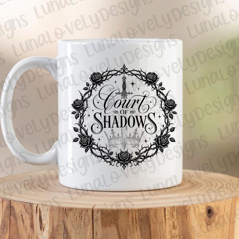 May include: White ceramic mug featuring the text "Court of Shadows" in a gothic font, surrounded by a black floral wreath with roses and thorns. A sword and two crowns are also featured in the design.