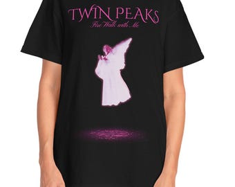 Może przedstawiać: Czarny t-shirt z różowym napisem "Twin Peaks" i hasłem "Fire Walk with Me". Poniżej znajduje się różowa grafika anioła. Koszulka ma wygodny krój i krótkie rękawy.