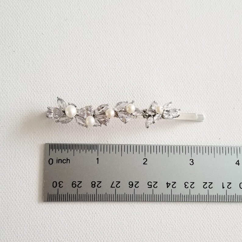 Hair clip beside ruler for measurements.