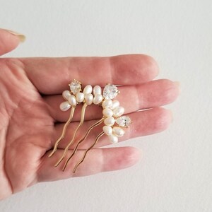 Puede incluir: Peine de pelo dorado con un grupo de perlas blancas y diamantes de imitaci&oacute;n transparentes.