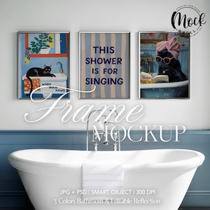 Op de afbeelding: Drie ingelijste illustraties in een badkameromgeving. De illustraties tonen een zwarte kat in een badkuip, een zwarte kat in een douche en een zwarte kat met een roze tulband die een boek leest. De tekst op de middelste illustratie luidt "This shower is for singing".