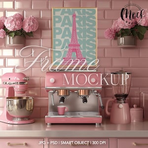Puede incluir: Una cocina rosa con una máquina de espresso rosa, una batidora de pie rosa y una licuadora rosa. Una impresión enmarcada con la palabra "París" repetida varias veces cuelga de la pared. La impresión presenta una Torre Eiffel rosa.