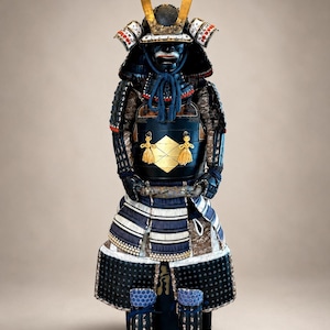 Könnte beinhalten: Eine vollständige Samurai-Rüstung mit einer dunkelblau und schwarz lackierten Brustplatte mit goldenem Emblem, einem Helm mit goldenen Verzierungen, blauen Kordelakzenten und Beinschutz. Die Rüstung zeigt aufwendige Schnürungen und Metallplatten.