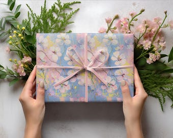 May include: A gift box wrapped in blue and pink floral patterned paper with a pink ribbon tied in a bow.