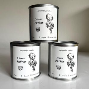 Peut inclure: Trois boîtes de bougies en métal argenté avec des étiquettes blanches. Chaque étiquette comporte le texte "Autumnfox_candles", "I choose Aether" et un graphisme. Les bougies sont étiquetées "Pear" et "Soywax", avec un poids net de 285g.