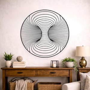 May include: A black metal wall art piece with a circular design. The artwork features a three-dimensional optical illusion with concentric lines creating a tunnel-like effect. The piece is mounted on a white wall.