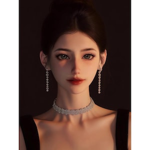 Puede incluir: Ilustración digital de una mujer con cabello oscuro recogido en un moño. Lleva un vestido negro, un collar de gargantilla plateado y pendientes colgantes a juego. Sus labios son rojos y sus ojos son de color verde claro. El fondo es oscuro.