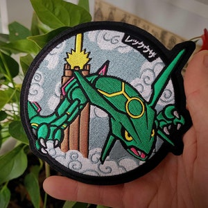 May include: A green and yellow embroidered patch of a Pokemon character, Rayquaza, with the Japanese text "レックウザ" on the patch.