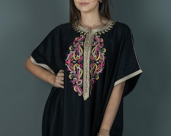 May include: A black kaftan with gold and colorful embroidery. The kaftan has a long, flowing silhouette and a V-neckline.