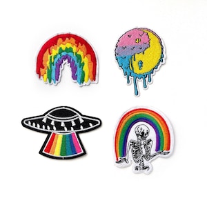Könnte beinhalten: Set aus vier gestickten Bügeletiketten mit einem Regenbogen, einem schmelzenden Yin-Yang-Symbol, einem UFO mit einem Regenbogen und einem Skelett, das einen Regenbogen hält.