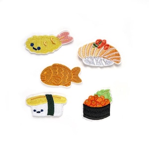 May include: Five embroidered iron-on patches featuring Japanese food: a shrimp tempura, a fish cake, a sushi roll with a smiling face, a nigiri sushi with a red topping, and a nigiri sushi with orange fish eggs.
